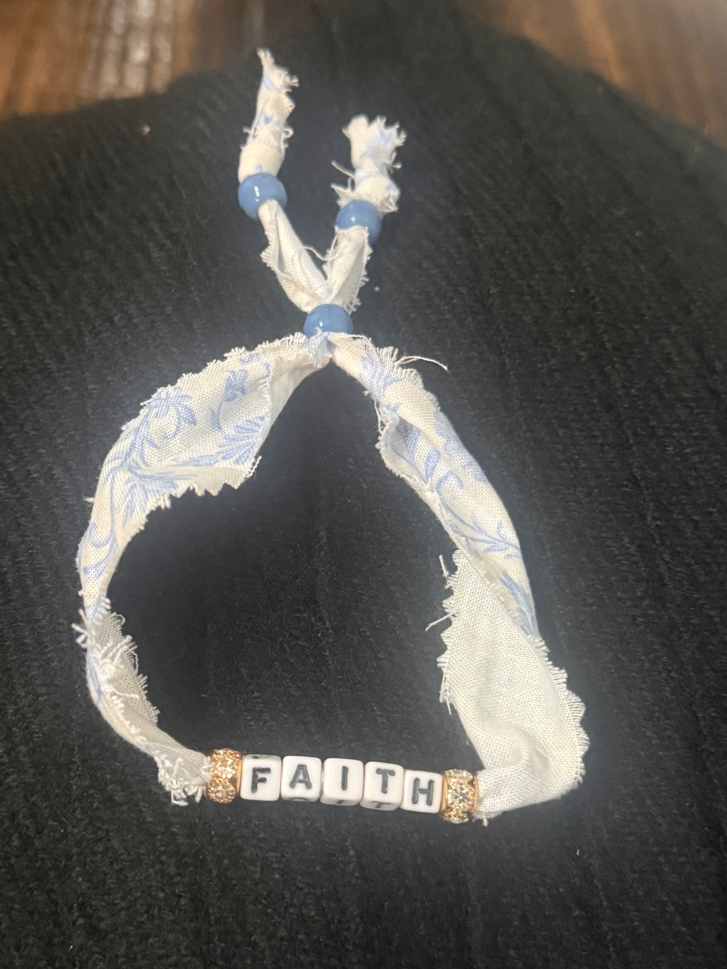 Blue floral fabric bracelet spelling FAITH with gold sparkle beads